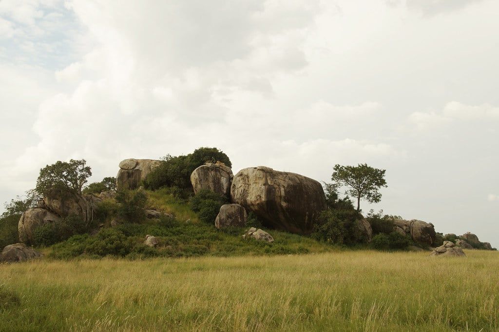 A large granite kopje rises above the grassy savanna plains in Serengeti National Park.